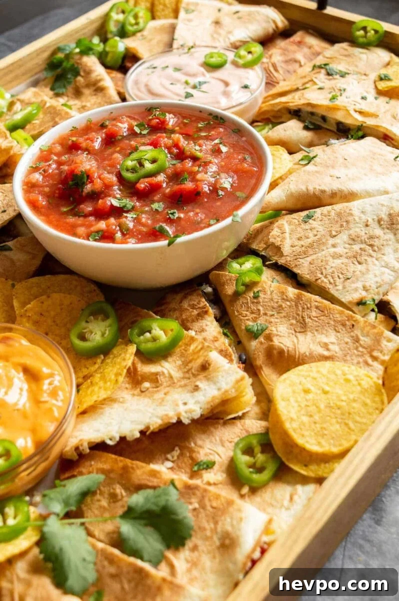How to Style a Show-Stopping Quesadilla Platter for Entertaining 3 Side view of a board with quesadillas, jalapeños and salsa.