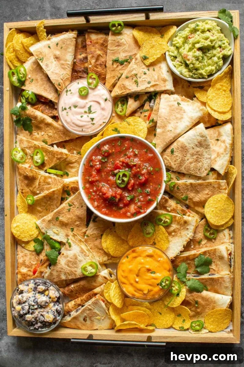 How to Style a Show-Stopping Quesadilla Platter for Entertaining 5 A wooden board with quesadillas and dips on it.