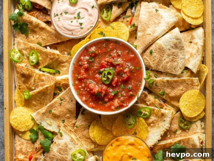 A wooden board with quesadillas and dips on it.