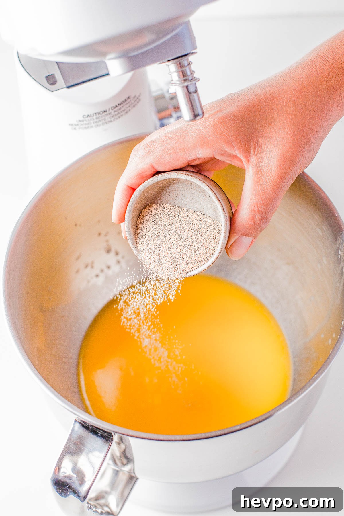 Yeast being poured into a mixture of wet ingredients. 