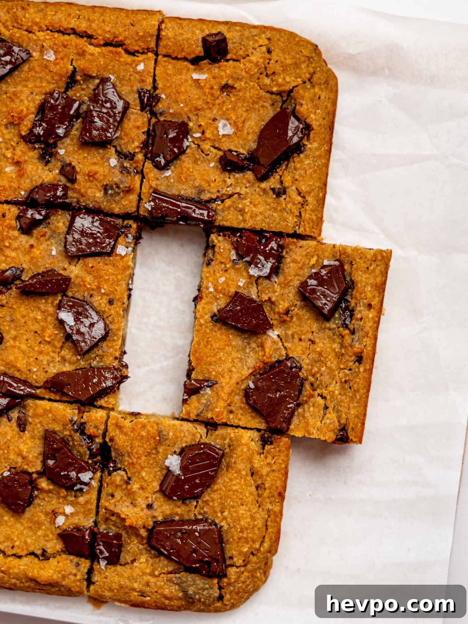 Chewy Chickpea Cookie Bars with Gooey Chocolate Swirls 3 Bird's eye view of healthy cookie bars on a sheet of white parchment paper.