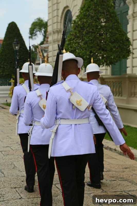 Guards carrying guns walking in the Grand Palace