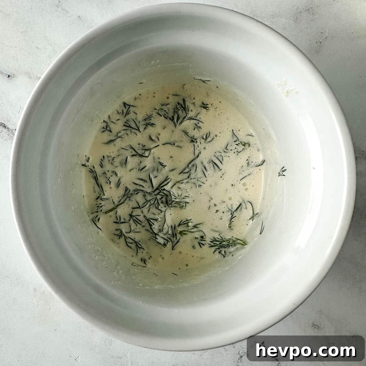 Creamy Dill Sauce for Fish, Salmon, and Vegetables 5 Finished creamy dill sauce in a white ramekin.