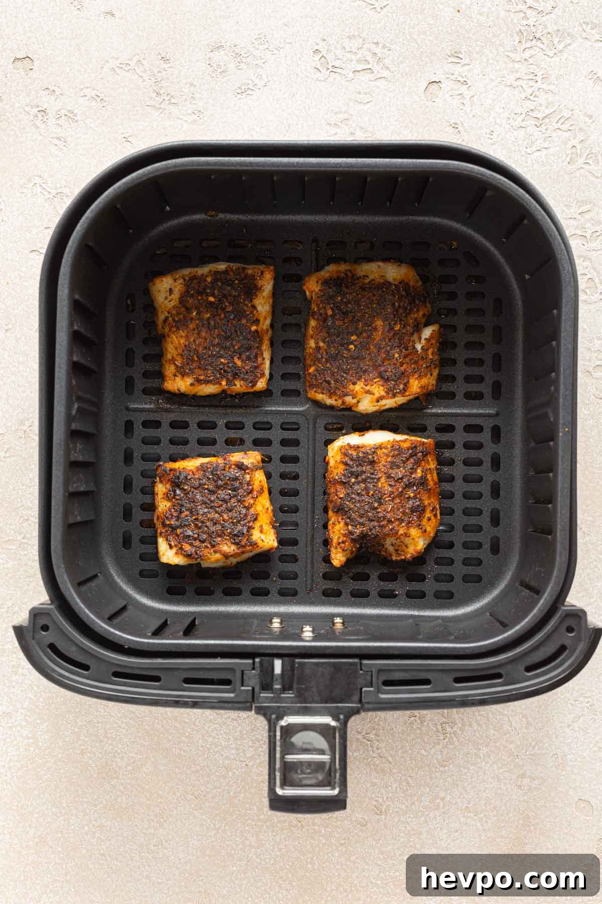 Crispy Air Fryer Fish Tacos with Tangy Slaw and Lime 5 Air fried cod pieces in an air fryer basket.