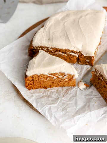 Pumpkin cake with cream cheese frosting cut into slices.
