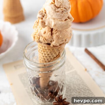 Creamy Pumpkin Ice Cream Recipe for Fall Desserts 15 Pumpkin pie ice cream in a cone and a mini pumpkin.