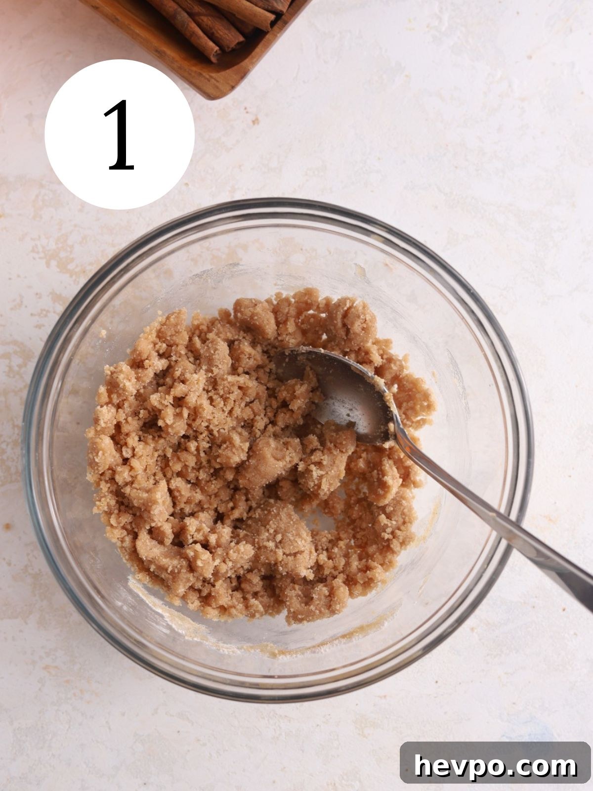 Creamy Pumpkin Ice Cream Recipe for Fall Desserts 4 Cinnamon crumble mixture stirred together in a glass bowl with a spoon.