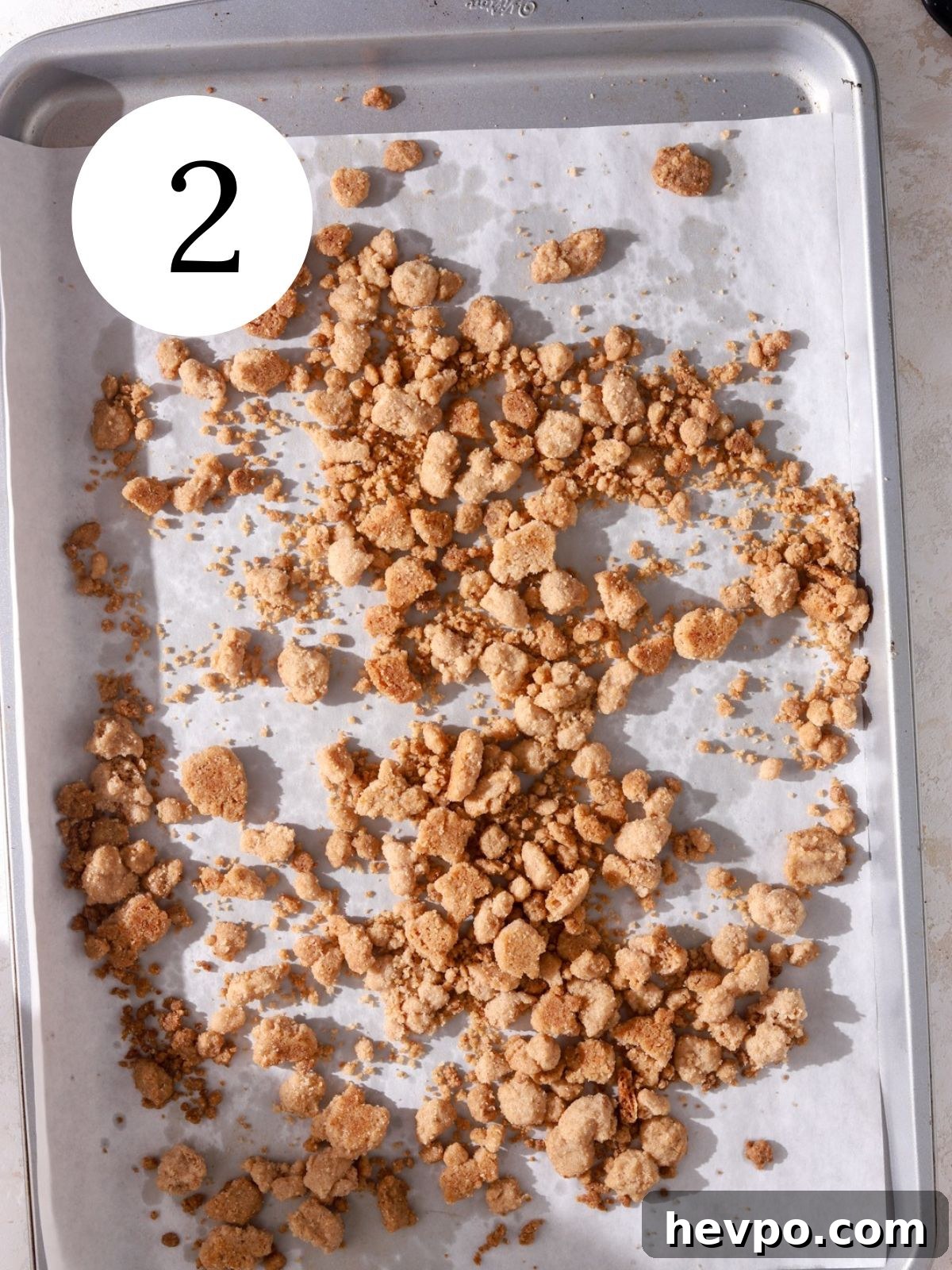 Creamy Pumpkin Ice Cream Recipe for Fall Desserts 5 A baking sheet lined with parchment paper with baked crumbles on it.