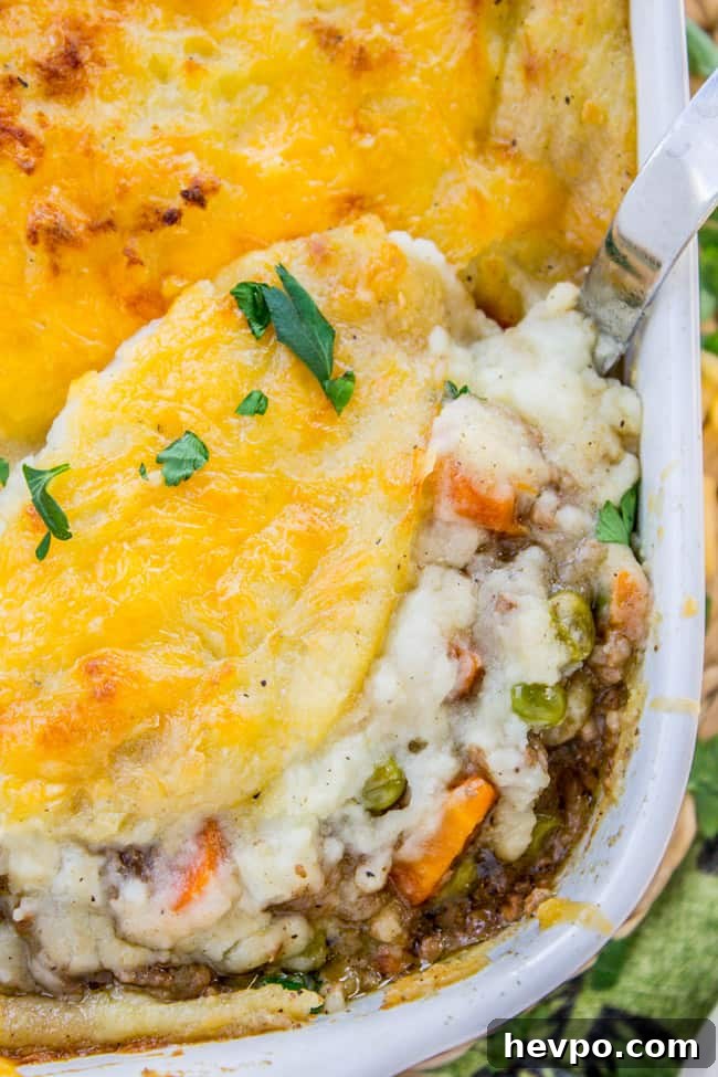 Classic Shepherd's Pie with Crispy Cheddar Topping shepherd's pie in a white baking dish with cheese on top.