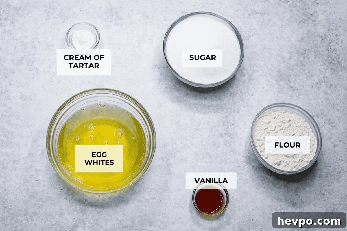 This light & fluffy Angel Food Cake is like a slice of heaven on a plate! It's delicious all on its own but absolutely divine topped with sweetened whipped cream and fresh berries or lemon curd! Overhead shot of labeled ingredients.