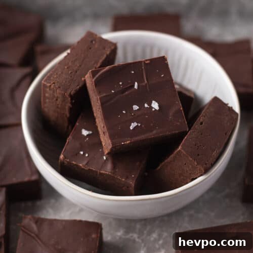 Closeup shot of cubes of dairy-free fudge in a white bowl.