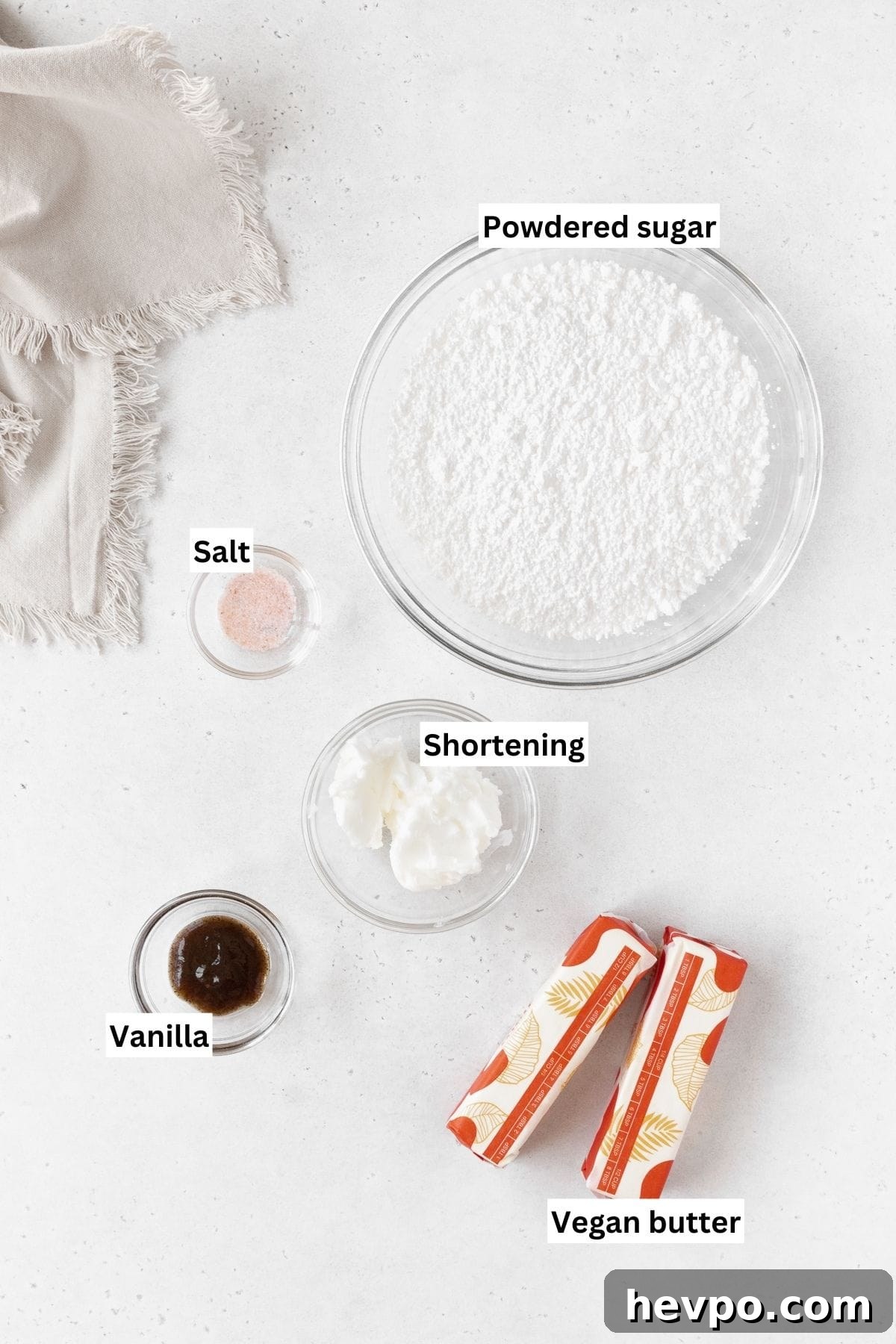 Ingredients needed to make dairy-free buttercream frosting laid out on a white table with text overlay.