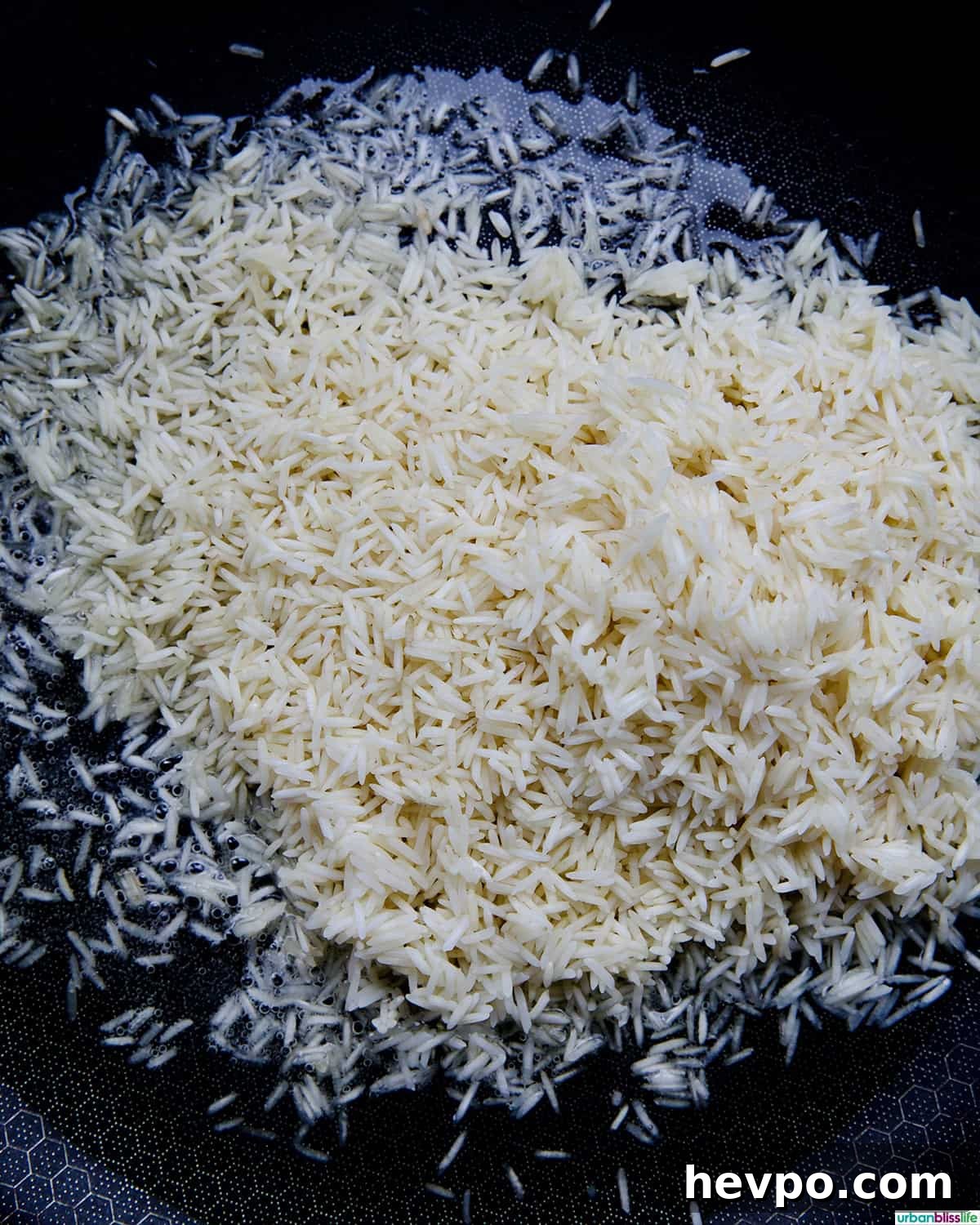 Authentic Vegetarian Mexican Rice Recipe — Flavorful & Simple 6 rice toasting in a skillet.