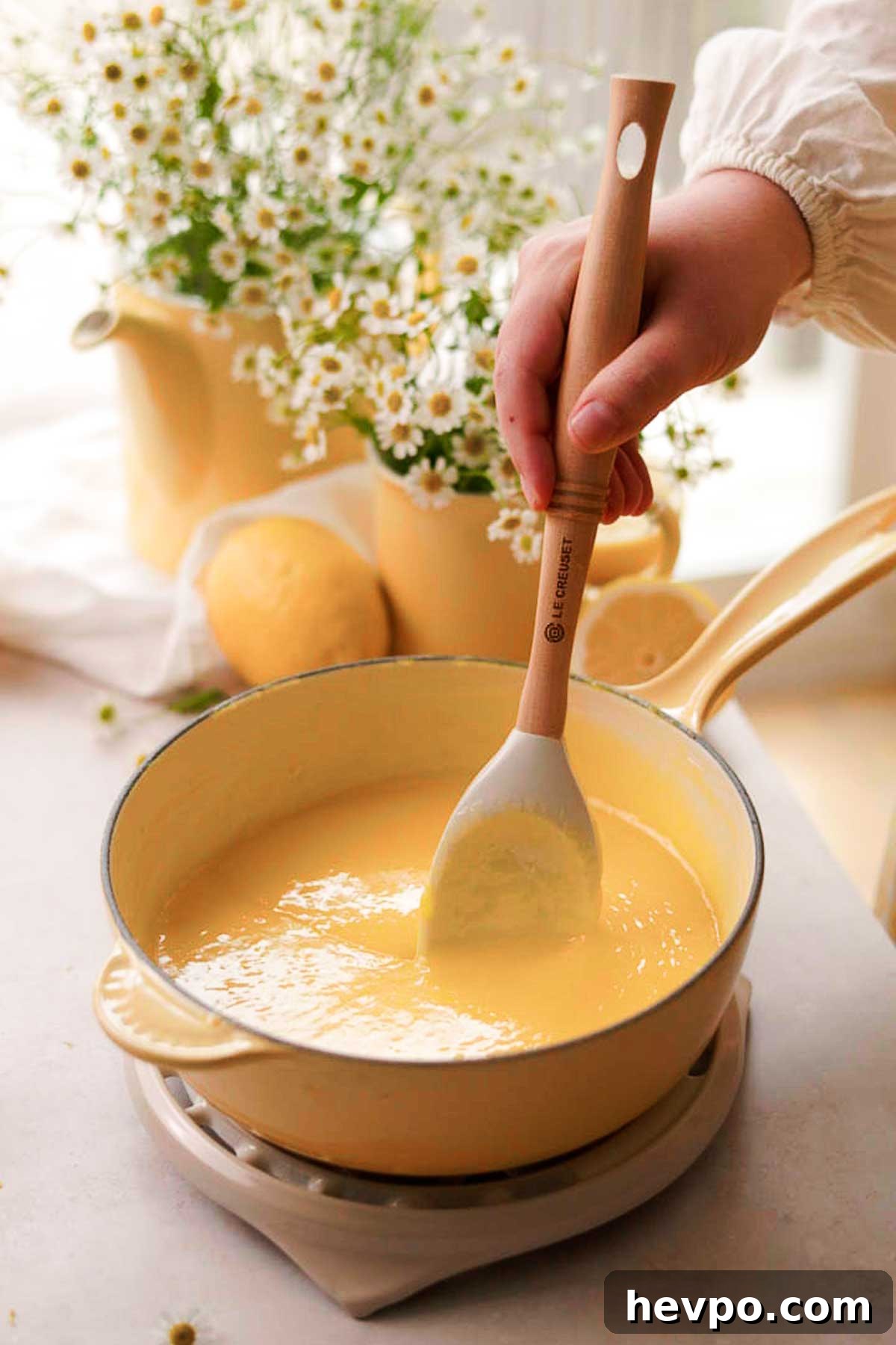 Moist Lemon Poke Cake Recipe with Zesty Lemon Glaze 12 stirring the cooked hot curd mixture with a spatula