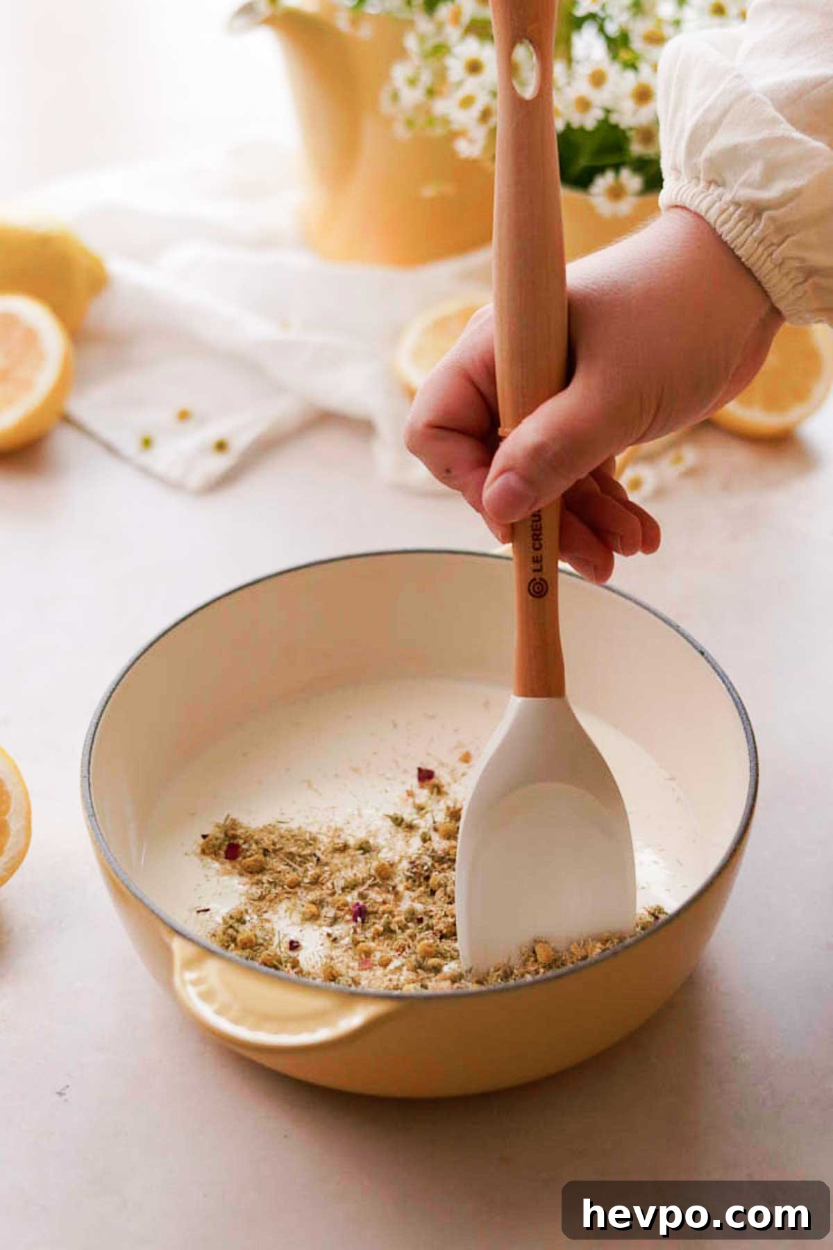 Moist Lemon Poke Cake Recipe with Zesty Lemon Glaze 13 adding and stirring chamomile tea in a pot of cream