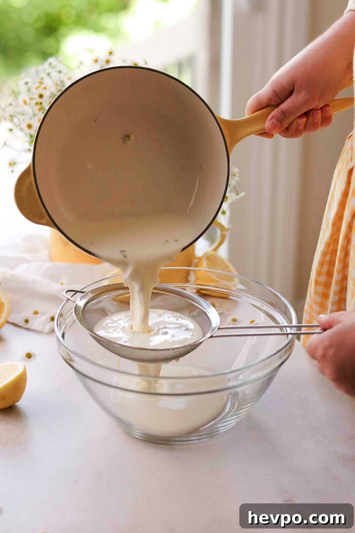 Moist Lemon Poke Cake Recipe with Zesty Lemon Glaze 14 pouring chamomile tea through a strainer
