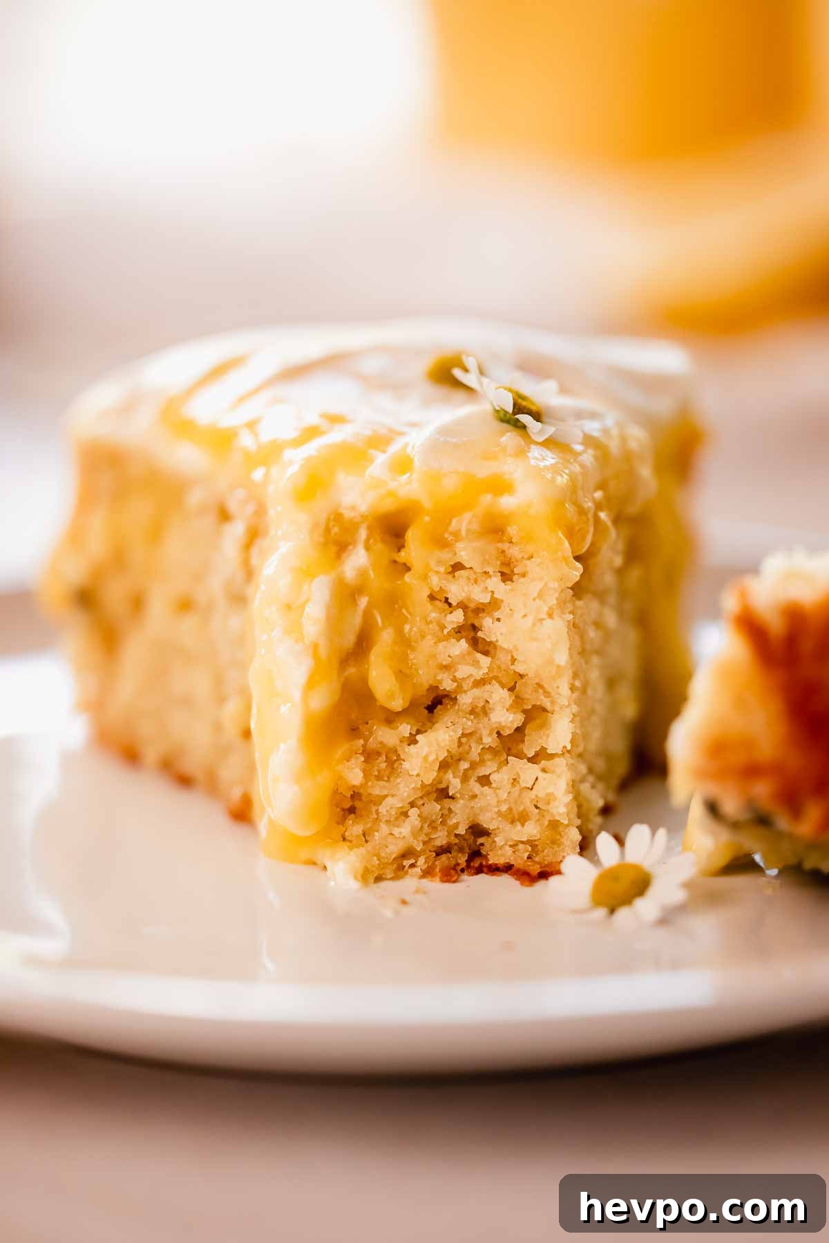 Moist Lemon Poke Cake Recipe with Zesty Lemon Glaze 19 close up of a cake bitten slice