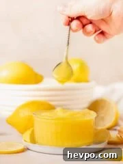 hand holding spoon with lemon curd
