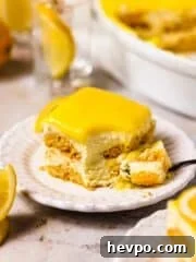 slice of creamy lemon tiramisu on white plate topped with lemon curd