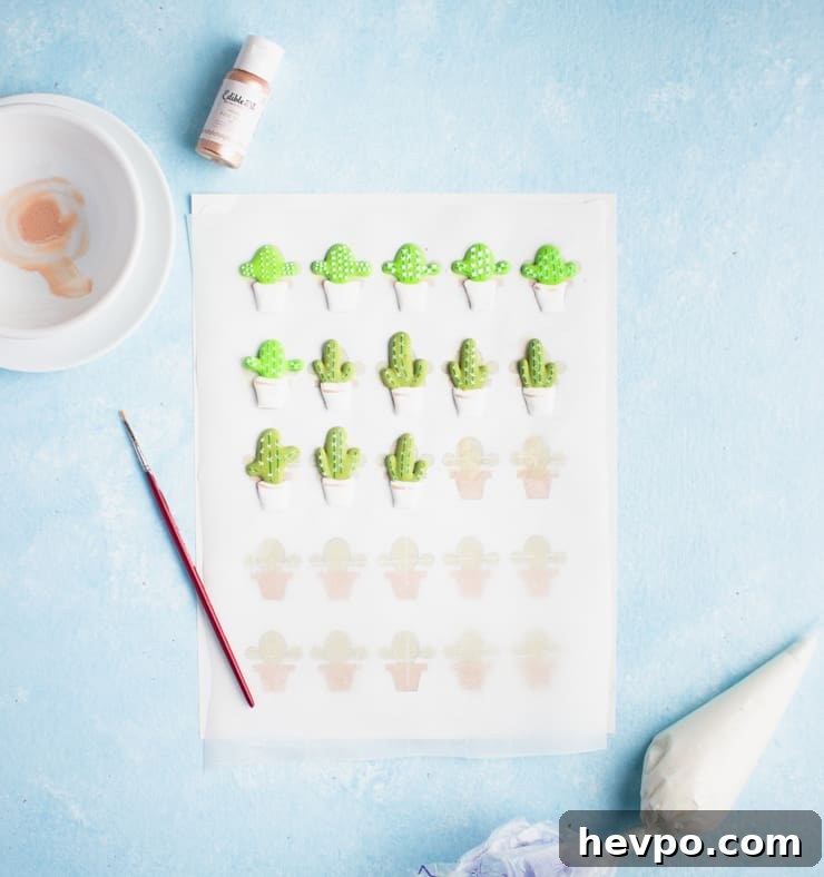 royal icing cacti on a piece of parchment