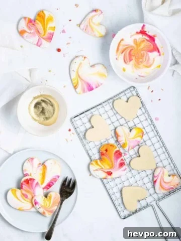 iced valentine cookies on a cooling rack with a bowl of icing next to them