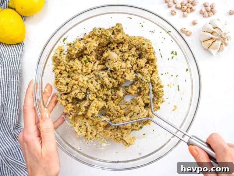 Step 1 Mixing chickpeas onion garlic herbs and spices in a large bowl for patties.