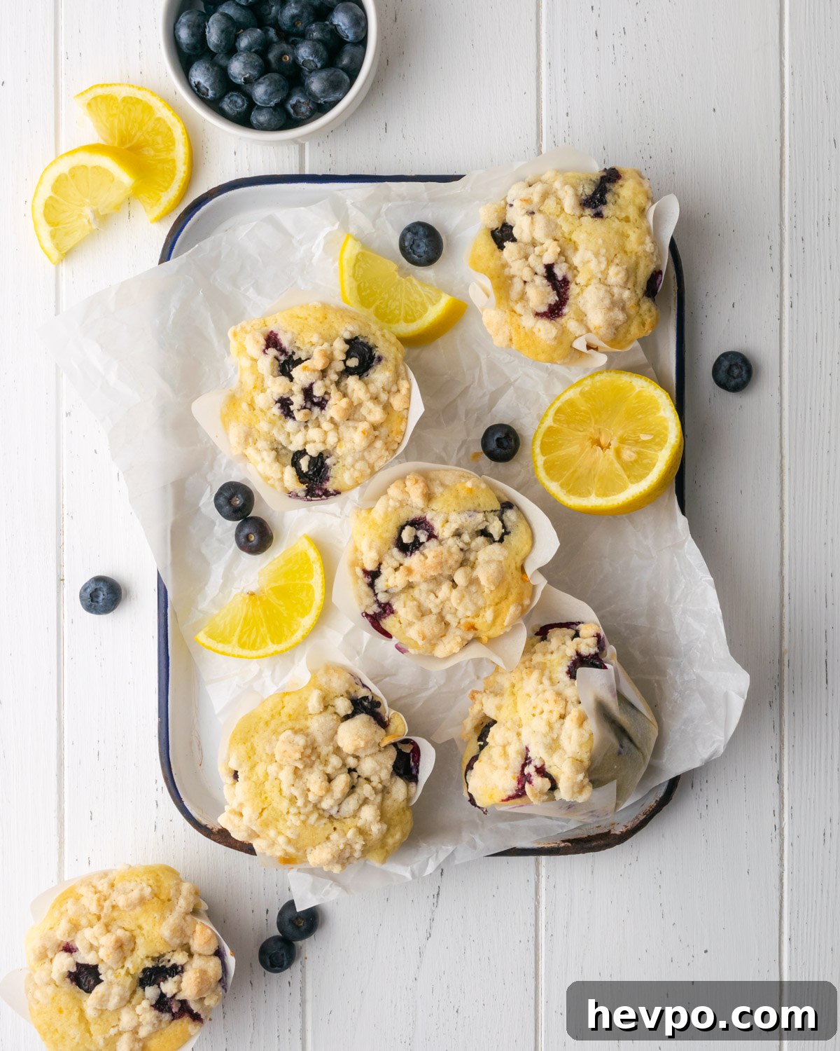 Gluten-Free Lemon Blueberry Muffins Recipe (Moist & Zesty) 2 Gluten free lemon blueberry muffins on a white tray.