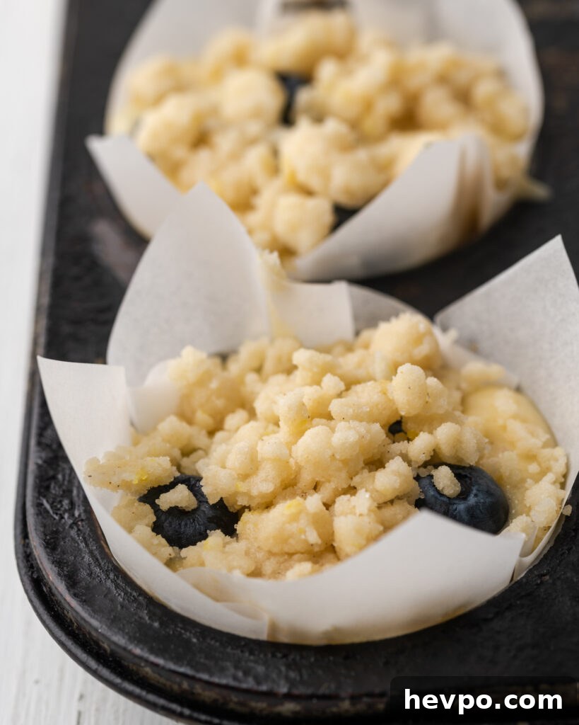 Gluten-Free Lemon Blueberry Muffins Recipe (Moist & Zesty) 11 Lemon crumble topping on unbaked muffin batter.