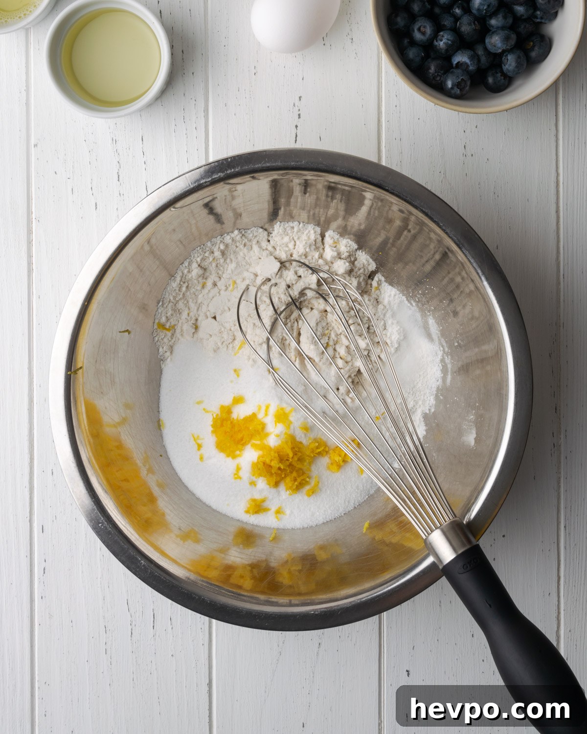 Gluten-Free Lemon Blueberry Muffins Recipe (Moist & Zesty) 4 Gluten free flour, sugar and lemon zest in a metal bowl.