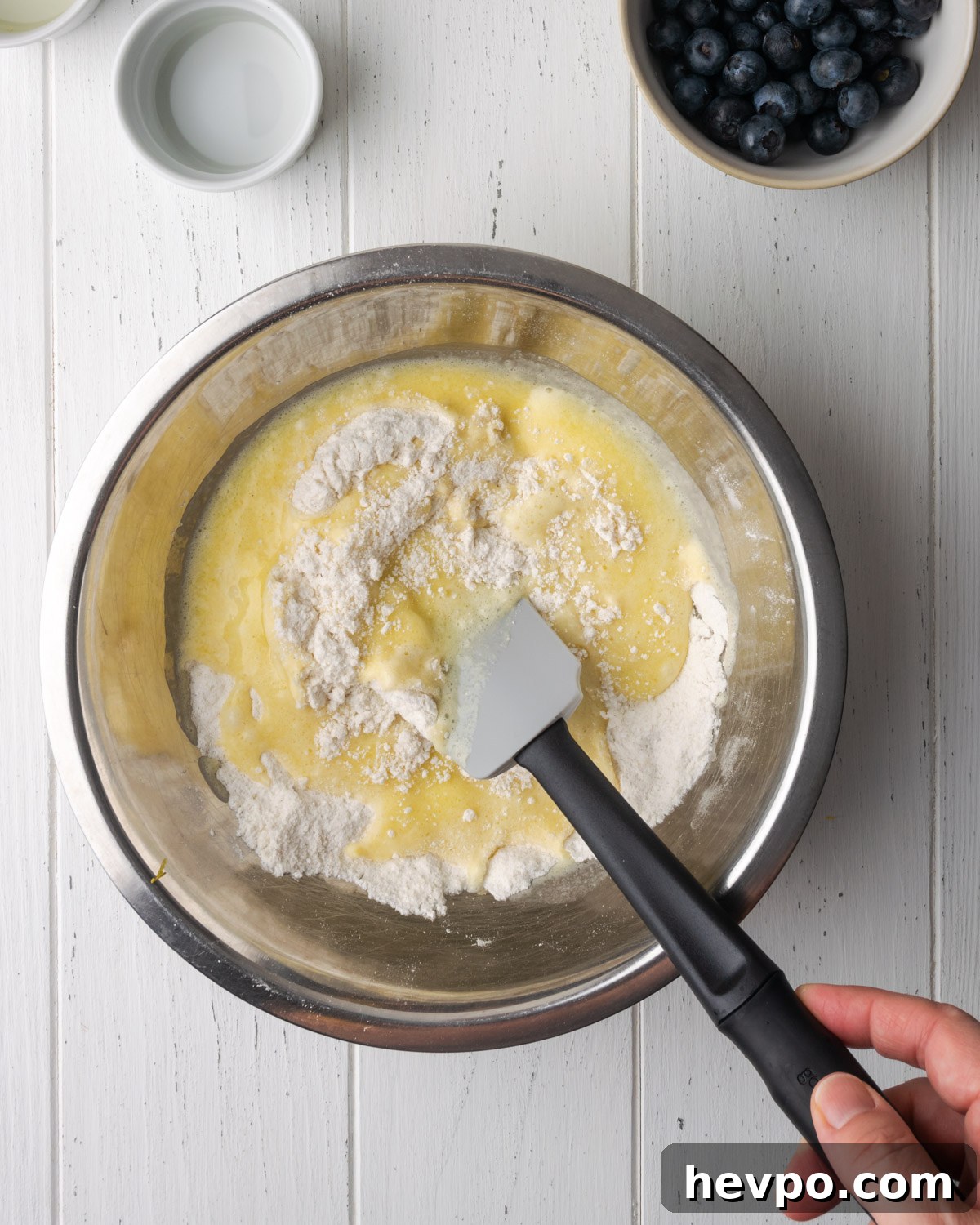 Gluten-Free Lemon Blueberry Muffins Recipe (Moist & Zesty) 7 Wet ingredients being added to dry ingredients.