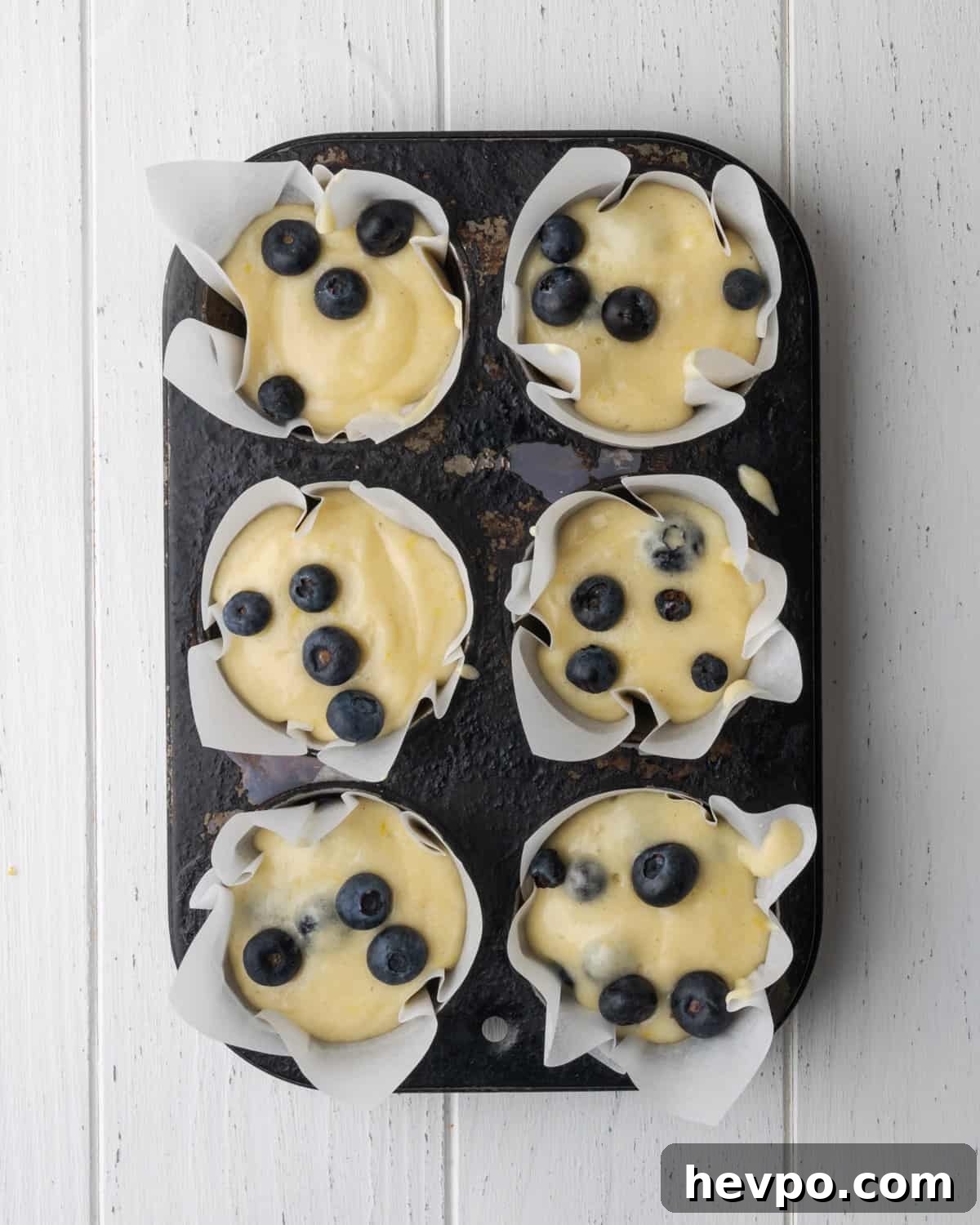Gluten-Free Lemon Blueberry Muffins Recipe (Moist & Zesty) 9 Unbaked muffin batter portioned into a 6 cup muffin tin.