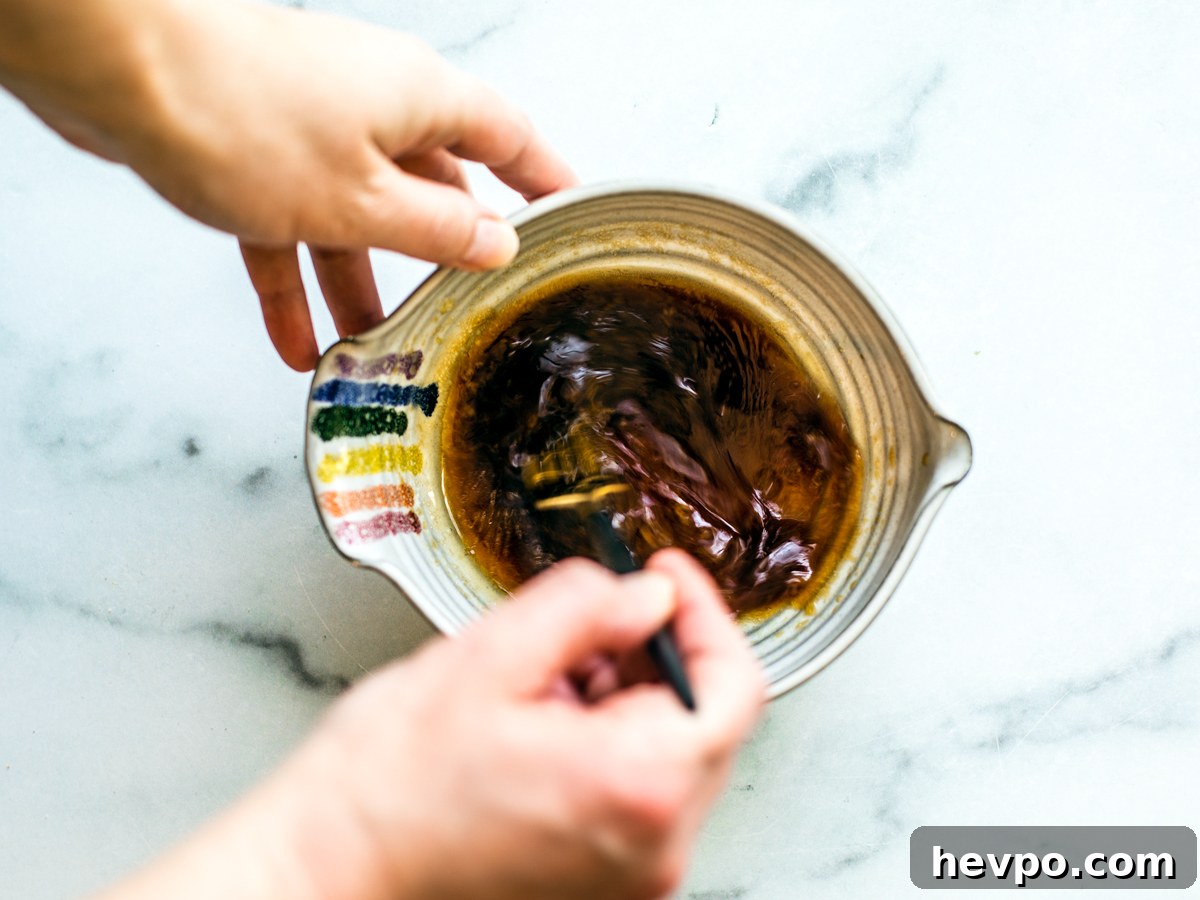 Hand mixing dressing in a small mixing bowl.