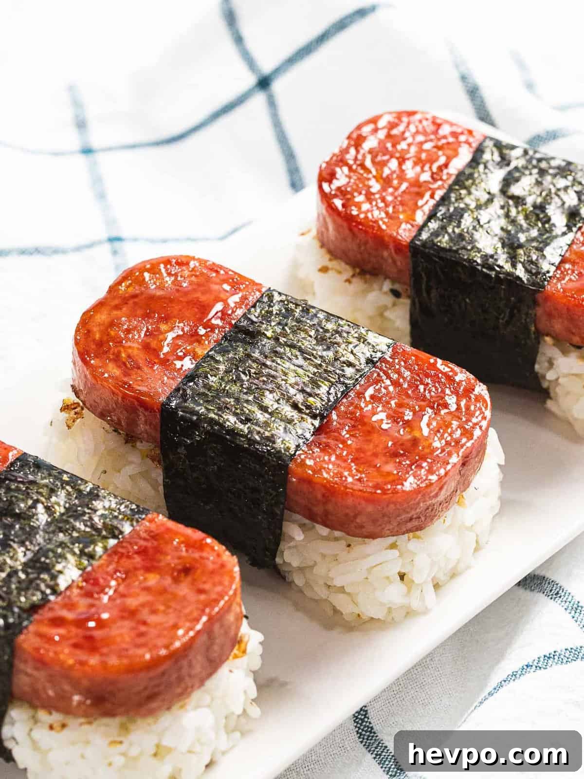 How to Make Spam Musubi: Simple Hawaiian Rice and Nori Snack 2 Spam musubi with rice, fried spam, and nori seaweed.
