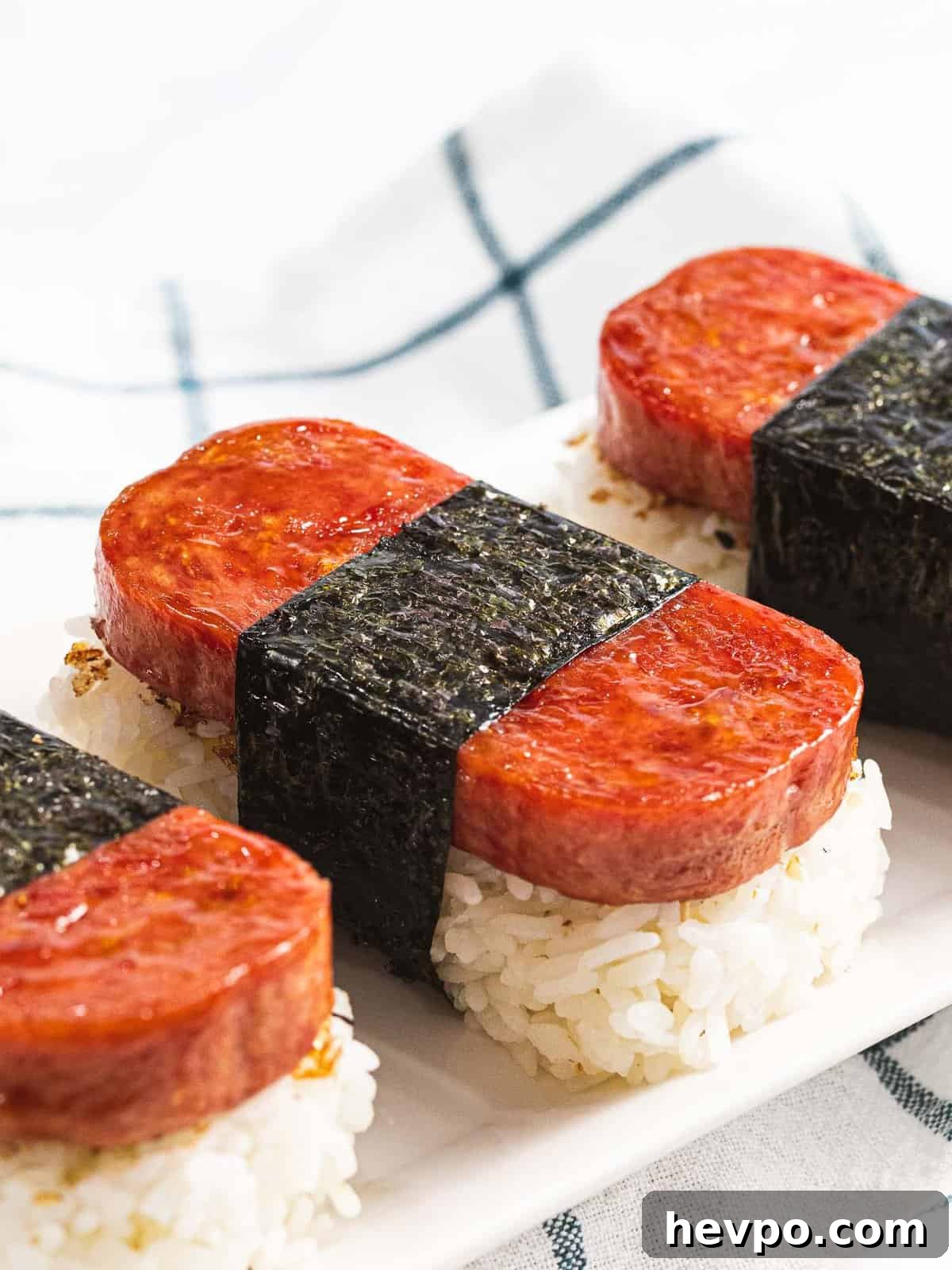 How to Make Spam Musubi: Simple Hawaiian Rice and Nori Snack 3 Spam musubi, rice topped with spam and wrapped in nori.