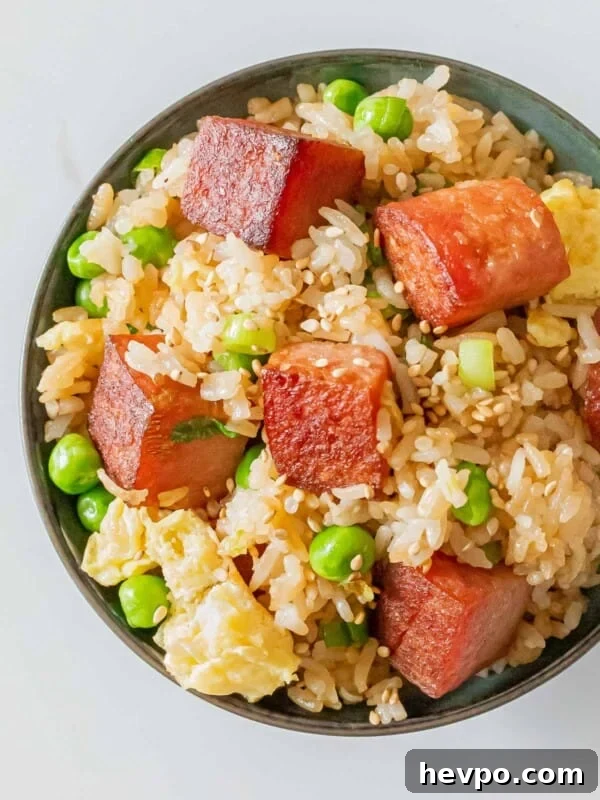 How to Make Spam Musubi: Simple Hawaiian Rice and Nori Snack 7 bowl of spam fried rice with crispy cubes of spam, eggs, green peas, and sesame seeds