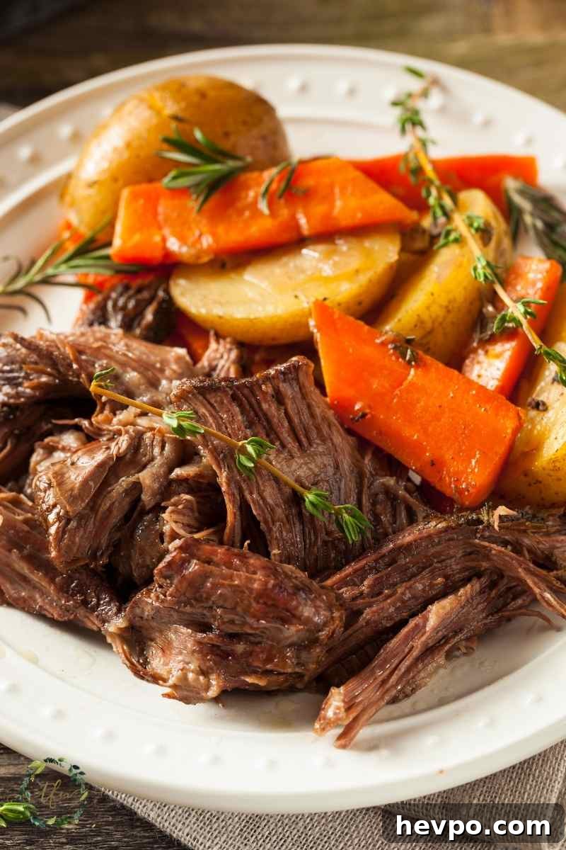 Slow-Cooked Crockpot Chuck Roast Recipe for Tender Beef 8 plate of pot roast chuck roast with carrots and potatoes.
