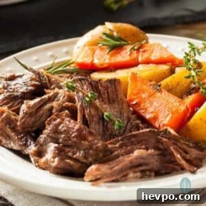 Slow-Cooked Crockpot Chuck Roast Recipe for Tender Beef 9 Platter full of chuck pot roast with carrots and potatoes.