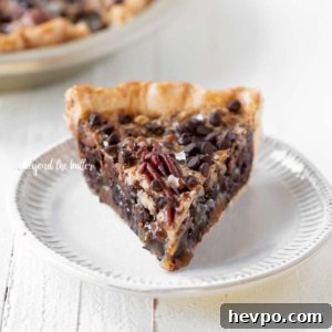 Slices of chocolate pecan pie on dessert plates on white wood table.