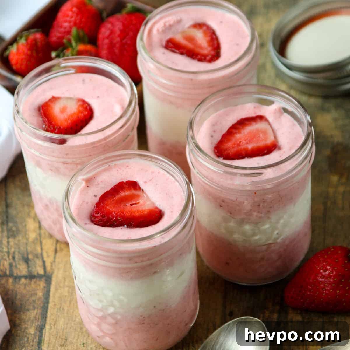 Four jars of mousse on a wooden table.