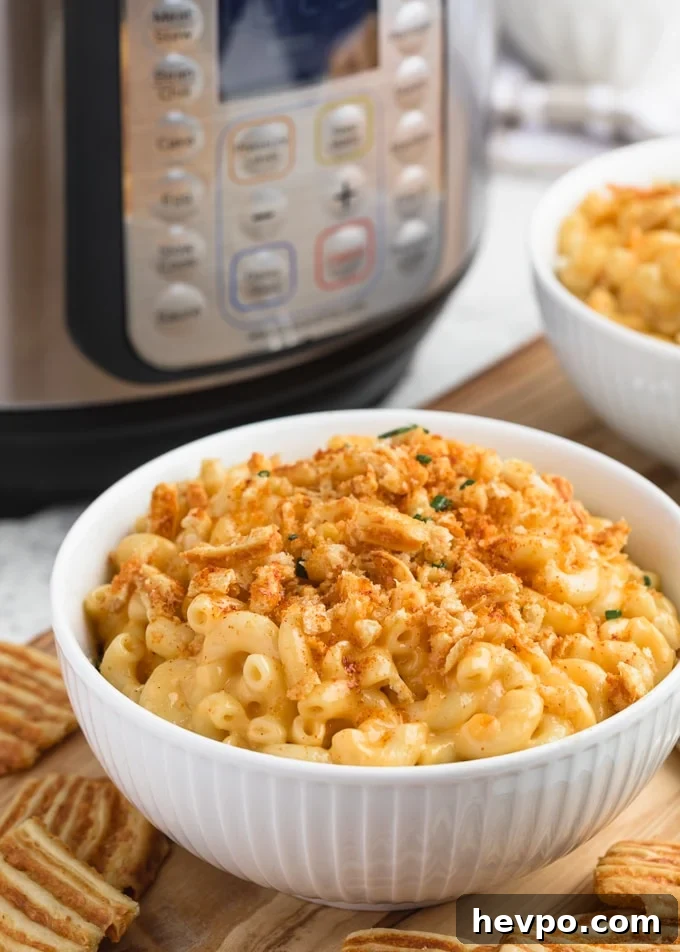 instant pot macaroni and cheese in a white bowl with crushed cheese crisps