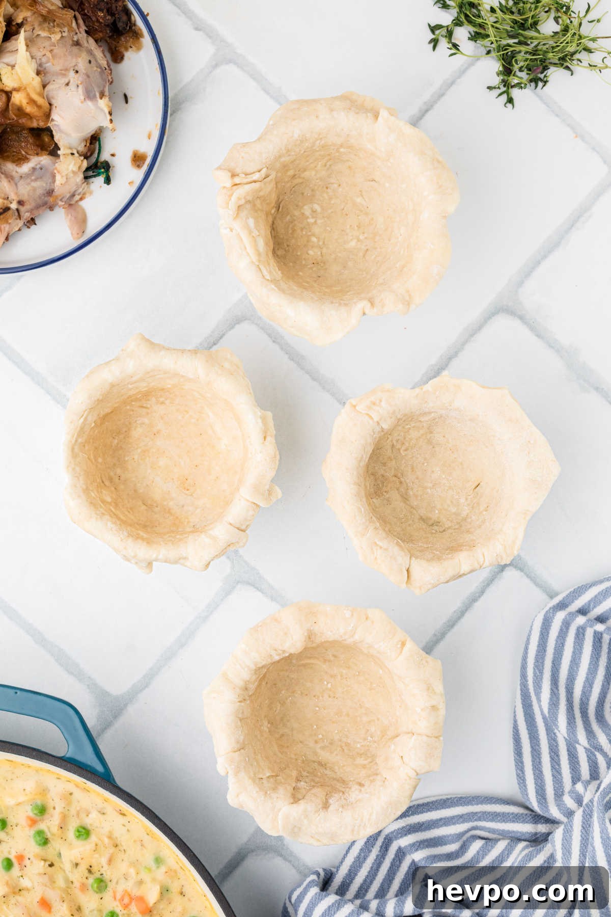 Four ramekin dishes with dough pressed into them.