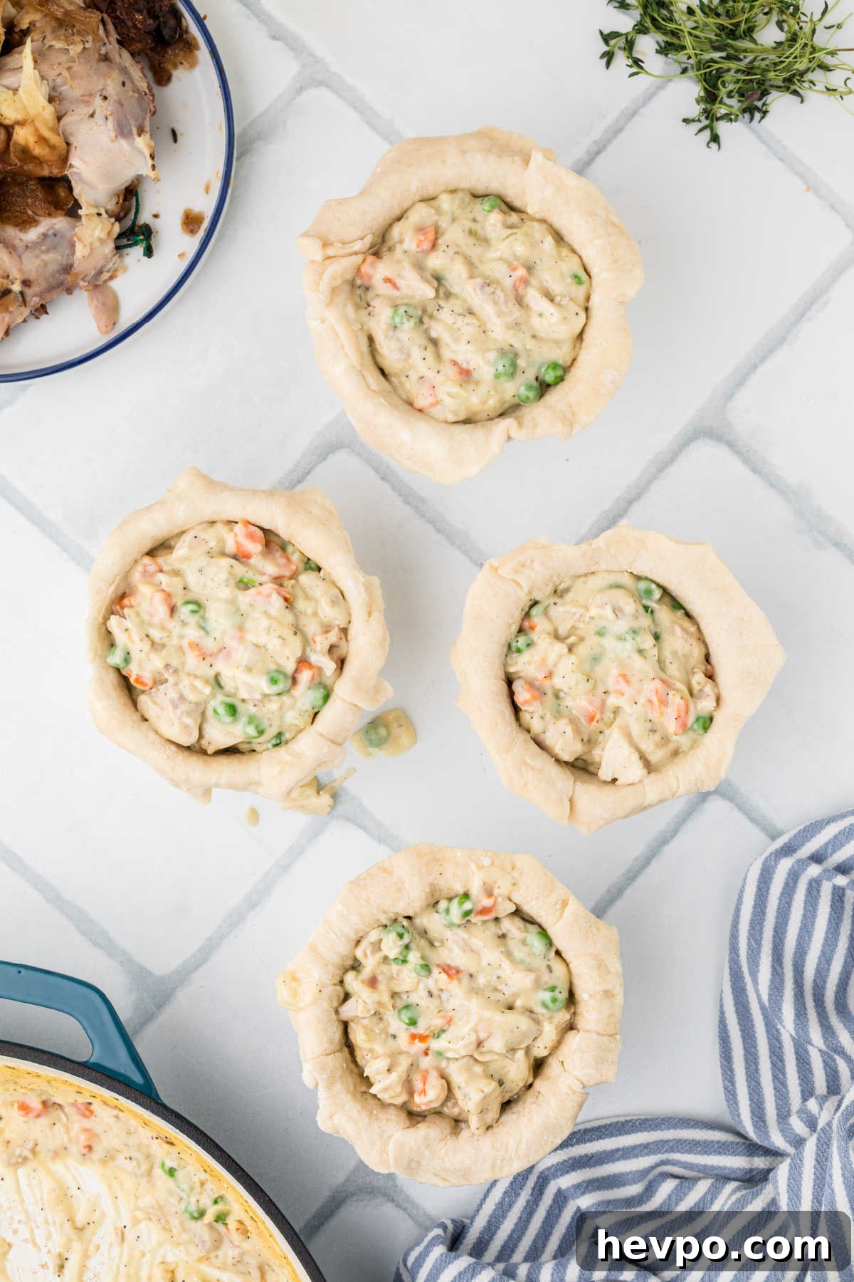 Chicken pot pie filling spooned into small individual mini pies.
