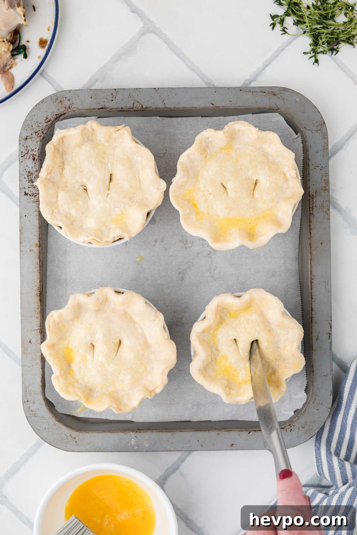 Mini Chicken Pot Pies, having slits cut into the top with a knife.