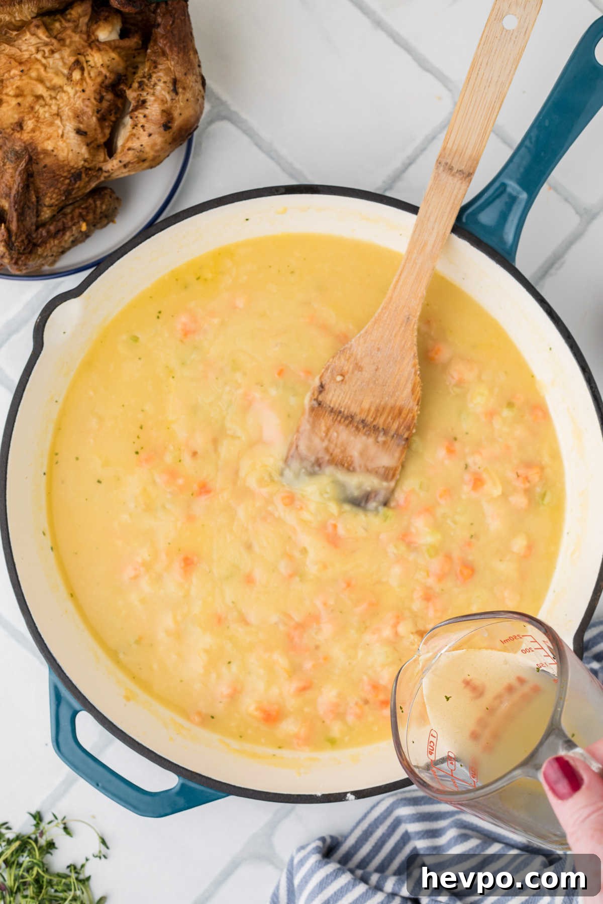 Chicken broth being poured into a heavy bottomed skillet.