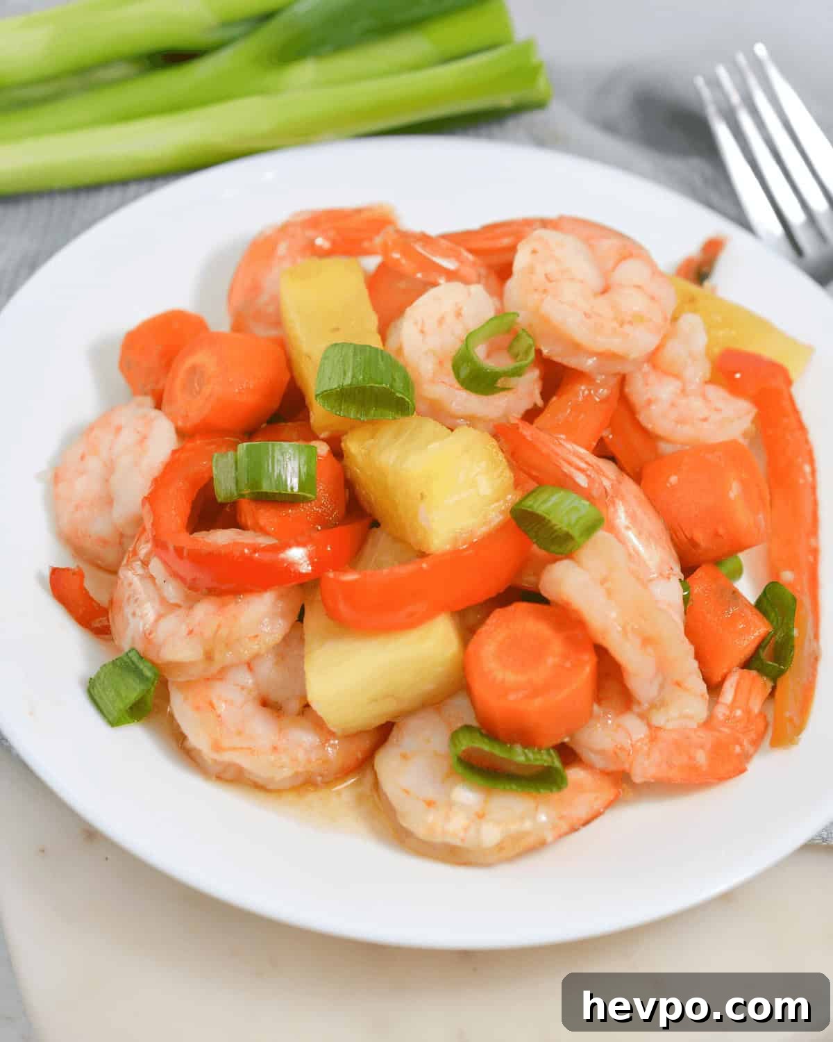 A plate with sheet pan shrimp teriyaki and pineapple.