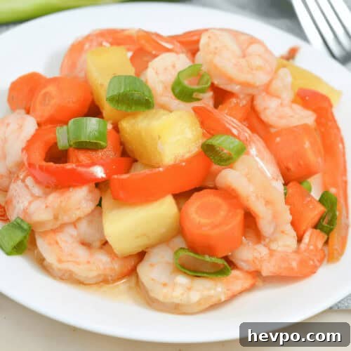 A sheet pan meal featuring succulent shrimp, crisp carrots, and crunchy celery on a white plate.