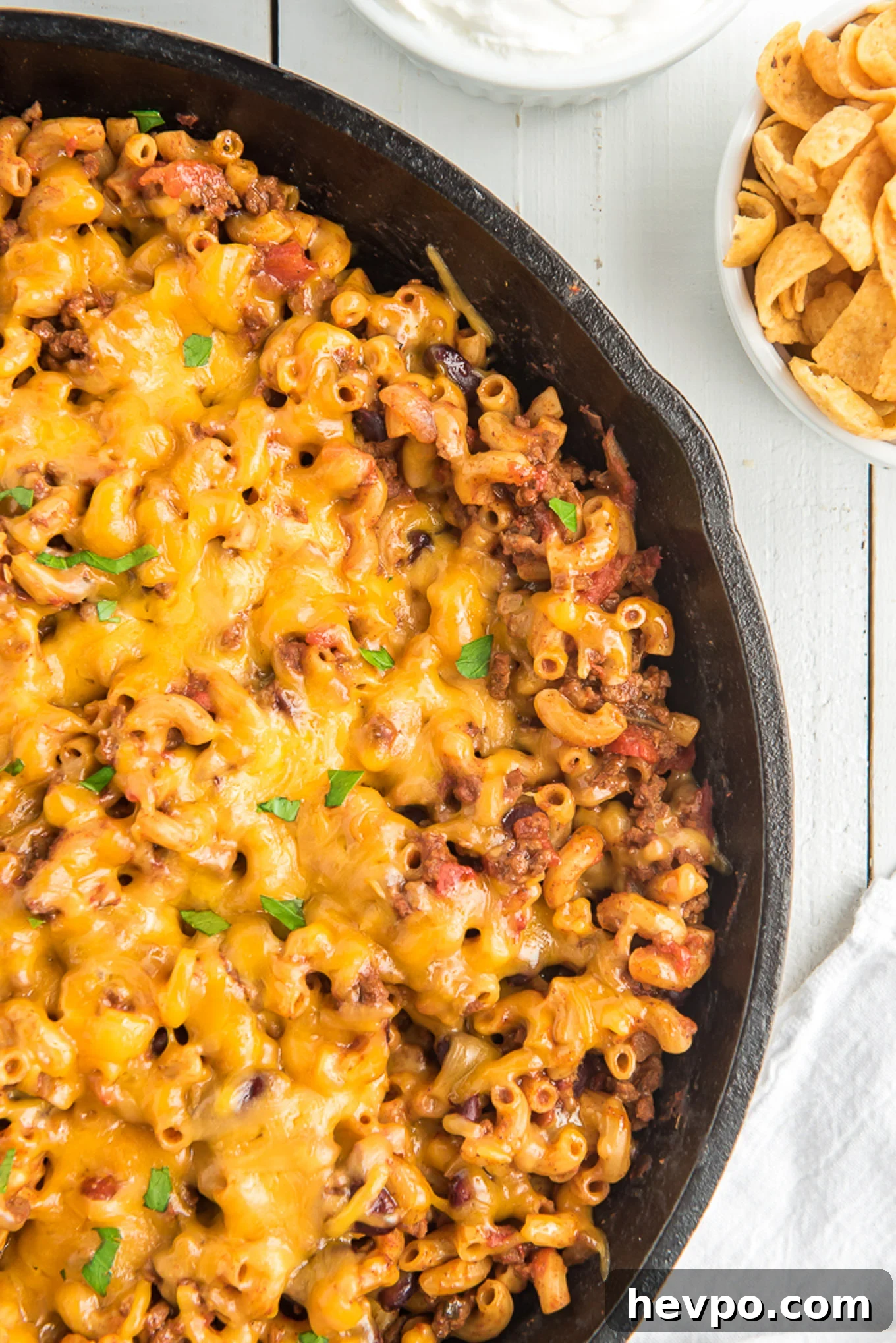 Hearty Chili Mac Recipe: Quick Comfort Food for Weeknights 2 Close up of a half a pan of chili mac in a skillet topped with cheese.