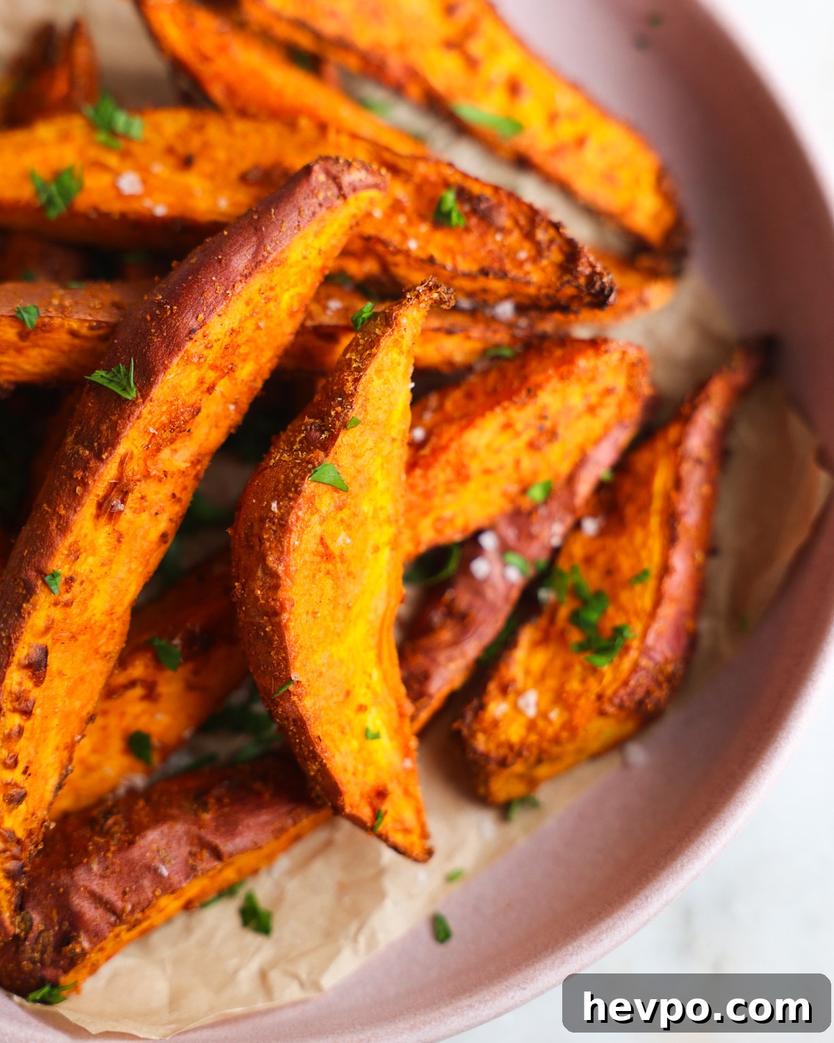 Crispy Air Fryer Sweet Potato Wedges Recipe 2 close up of sweet potato wedges on a pink plate