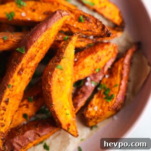 Crispy Air Fryer Sweet Potato Wedges Recipe 13 close up of sweet potato wedges on a pink plate