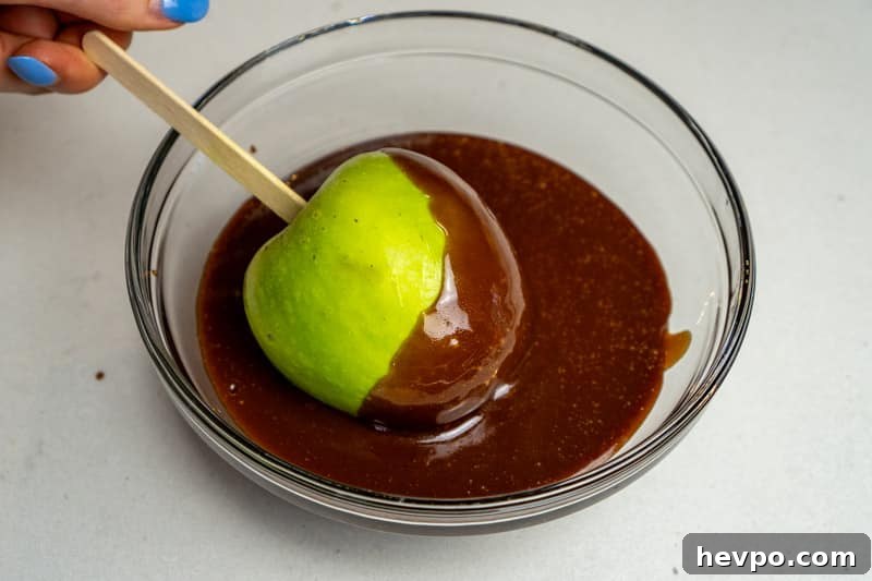 Dipping the apple into caramel
